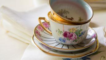 A couple of fine china cups sit nestled atop a couple of saucers